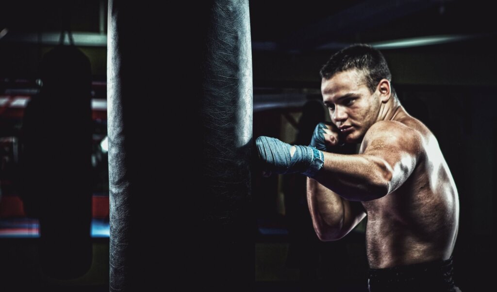 man in blue pants and black boxing gloves